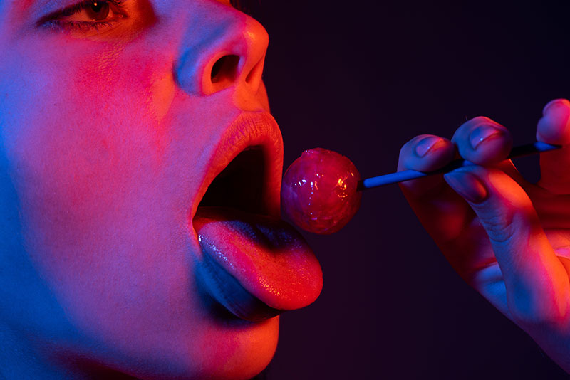 Frau übt mit Lollipop für Deepthroat